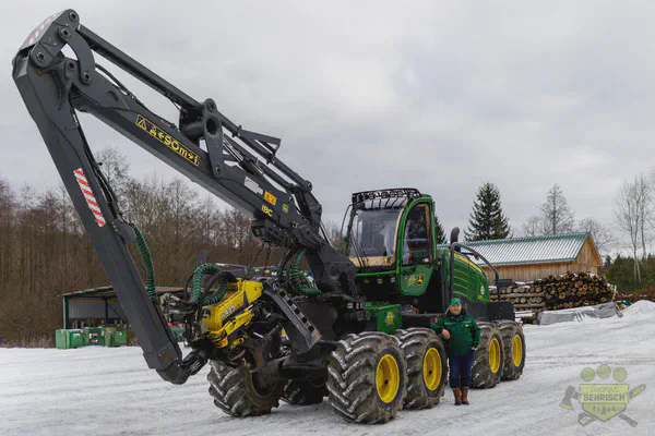 John Deere Harvester mit Kesla-Aggregat auf dem schneebedeckten Betriebsgelände